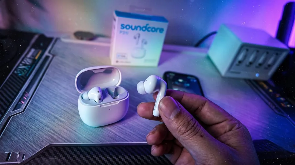 Anker Soundcore P31i true wireless earbuds with silicone ear tips resting on their sleek pebble charging case
